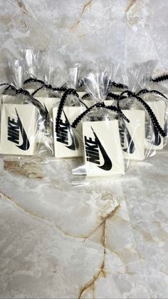 three bags with nike logos on them sitting on a marble counter top, wrapped in clear cellophane