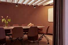 a long table with chairs around it in the middle of a room that has wood paneling on the walls