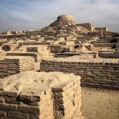 the ruins of an ancient city with a large dome in the middle and other structures around it