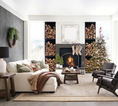 a living room filled with furniture and a fire place covered in stockings next to a christmas tree