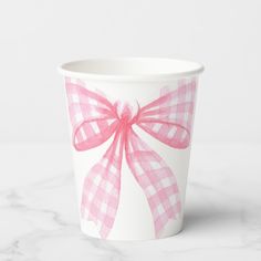 a paper cup with a pink bow on it