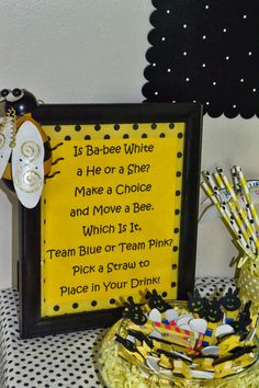 a yellow and black baby shower sign next to a basket filled with toothbrushes