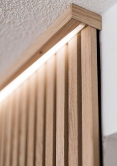 a close up of a light that is on the side of a wall with wood slats