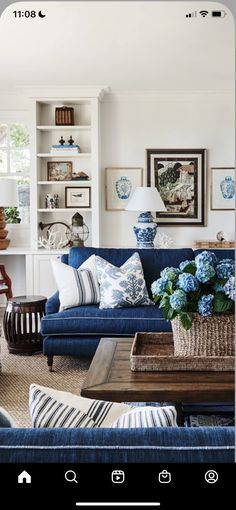 a living room with blue couches and pictures on the wall above them in an instagram