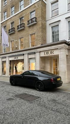 a black car parked in front of a tall building