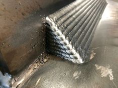 a piece of metal sitting on top of a table next to a pile of dirt