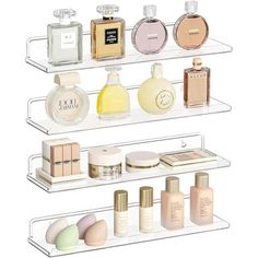 three clear shelves holding different types of perfumes and body care products on white background