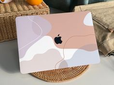 an apple laptop sitting on top of a wicker basket