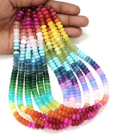 multicolored beads are being held by a hand