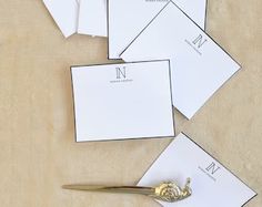 a pair of scissors sitting on top of some white cards and envelopes next to each other