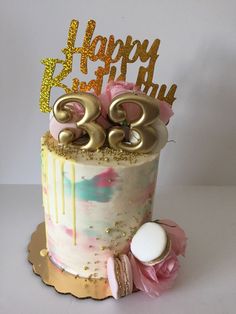 a birthday cake decorated with gold numbers and flowers