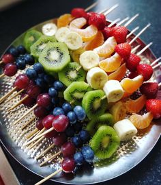 fruit skewers are arranged on a plate with toothpicks