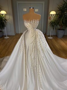 a white wedding dress on display in a room