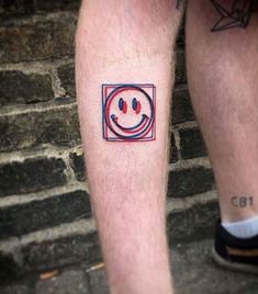 a man with a smiley face tattoo on his leg