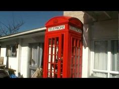 a red telephone booth in front of a building