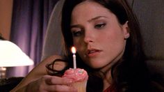 a woman holding a cupcake with a candle in it