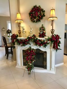 a fireplace decorated for christmas with wreaths and lights