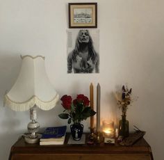 a table with flowers, candles and pictures on the wall