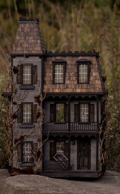 a doll house sitting on top of a rock