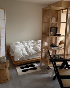 a bed room with a neatly made bed next to a wooden book shelf filled with books