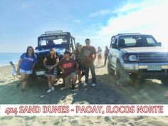 some people are posing for a photo on the beach with their jeeps and truck