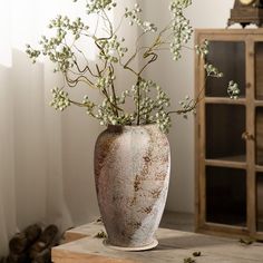 a vase filled with white flowers on top of a wooden table