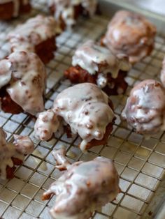 there are many donuts that have been frosted with icing on the cooling rack