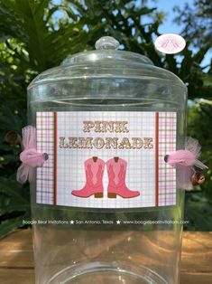 a pink lemonade jar is sitting on a table