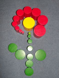 a group of red and green circles sitting on top of a gray floor next to a yellow circle