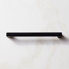 a black pen sitting on top of a white table next to a marble countertop