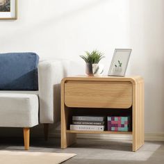 a living room with a white couch and a wooden end table on carpeted floor