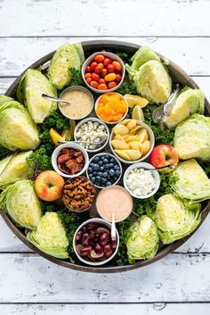 a platter filled with lots of different types of vegetables and dips on top of each other