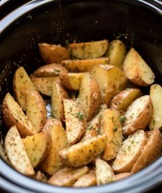 cooked potatoes in a crock pot with seasoning sprinkled on top, ready to be eaten