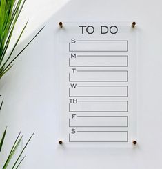 a menu is hanging on the wall next to a potted plant