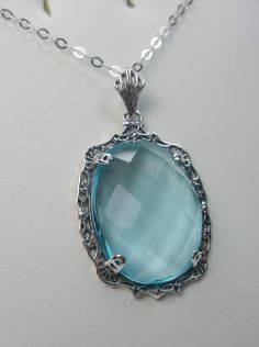 "Simulated Blue Aquamarine Necklace Bubble Design#P10 Custom Made Inspired by Victorian era designs, I now offer this lovely Antique reproduction in sterling silver. The flawless 22ct faceted simulated/Man-made blue Aquamarine is 24mm long (15/16th\") and 18mm in width (3/4th\"). The entire pendant is 1.5\" long and 7/8\" wide. The chain (if chosen) is between 16-18\" in length and is marked 925 as well. Notice the beautiful craftsmanship of the Victorian filigree setting. This pendant necklace Blue Aquamarine Pendant Necklace, Blue Aquamarine Necklaces For Jewelry Making, Nickel-free Blue Necklaces For Wedding, Elegant Handmade Light Blue Necklace, Elegant Handmade Light Blue Necklaces, Elegant Light Blue Handmade Necklaces, Formal Blue Handmade Necklace, Formal Handmade Blue Necklace, Blue Nickel-free Necklaces For Wedding