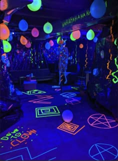 a room filled with neon colored lights and balls on the floor, all lit up in different colors