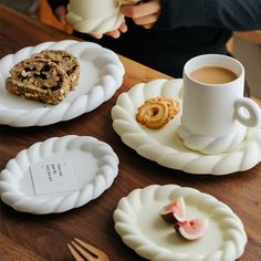 there are three plates with food on them and one has a cup of coffee in it