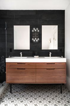 a bathroom with two sinks and mirrors on the wall