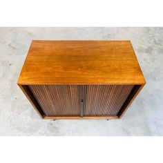 a wooden cabinet sitting on top of a cement floor