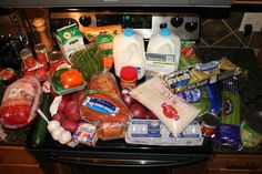 an open refrigerator filled with lots of food and condiments on top of it