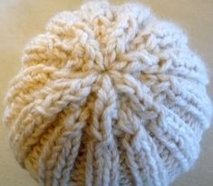 a white knitted hat sitting on top of a table