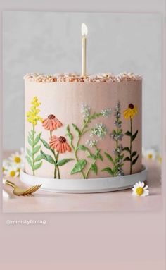 a birthday cake decorated with flowers and candles