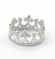 a white gold ring with diamonds on the sides and a crown design in the middle