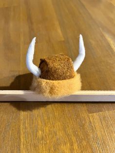 an animal's head is placed on the edge of a piece of white wood