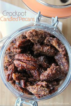 a jar filled with candied pecans sitting on top of a table