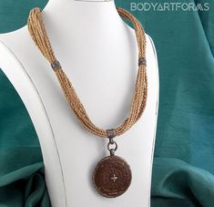 Sold as a single. Artist Lou Zeldis was an American who lived for many years in Indonesia where he worked with the native people. He crafted his modern designs with ancient techniques.All measurements are approximateThe coconut wood pendant is 1-11/16" in diameter. The necklace is 20" long. The clasp and other metal hardware is made from oxidized sterling silver. You will receive the exact jewelry photographed Material(s): Coconut wood, Sterling Silver, Wood. Sizes offered: 14g (1.6mm). Brand: I Traditional Natural Color Round Jewelry, Brown Carved Round Pendant Necklace, Artisan Carved Medallion Necklace, Brown Medallion Amulet Necklace, Wooden Beads Amulet Pendant Jewelry, Brown Amulet Style Necklace With Round Pendant, Brown Amulet Necklace With Round Pendant, Brown Amulet Style Round Pendant Necklace, Traditional Brown Engraved Jewelry