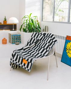 a black and white blanket sitting on top of a chair