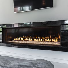 a modern fireplace in the middle of a room with a flat screen tv above it