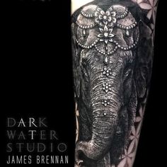 an elephant with jewels on its head is shown in this black and grey tattoo design