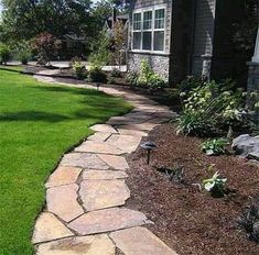 a stone walkway in front of a house